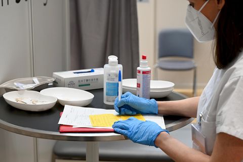 Ärztin füllt einen Impfpass als Impfbescheinigung aus
