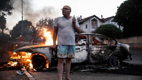 Fassungslos steht Jacob Simona vor seinem brennenden Auto in der israelischen Stadt Lod