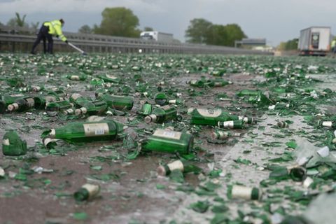 Zerstörte Bierflaschen liegen auf der Autobahn. 