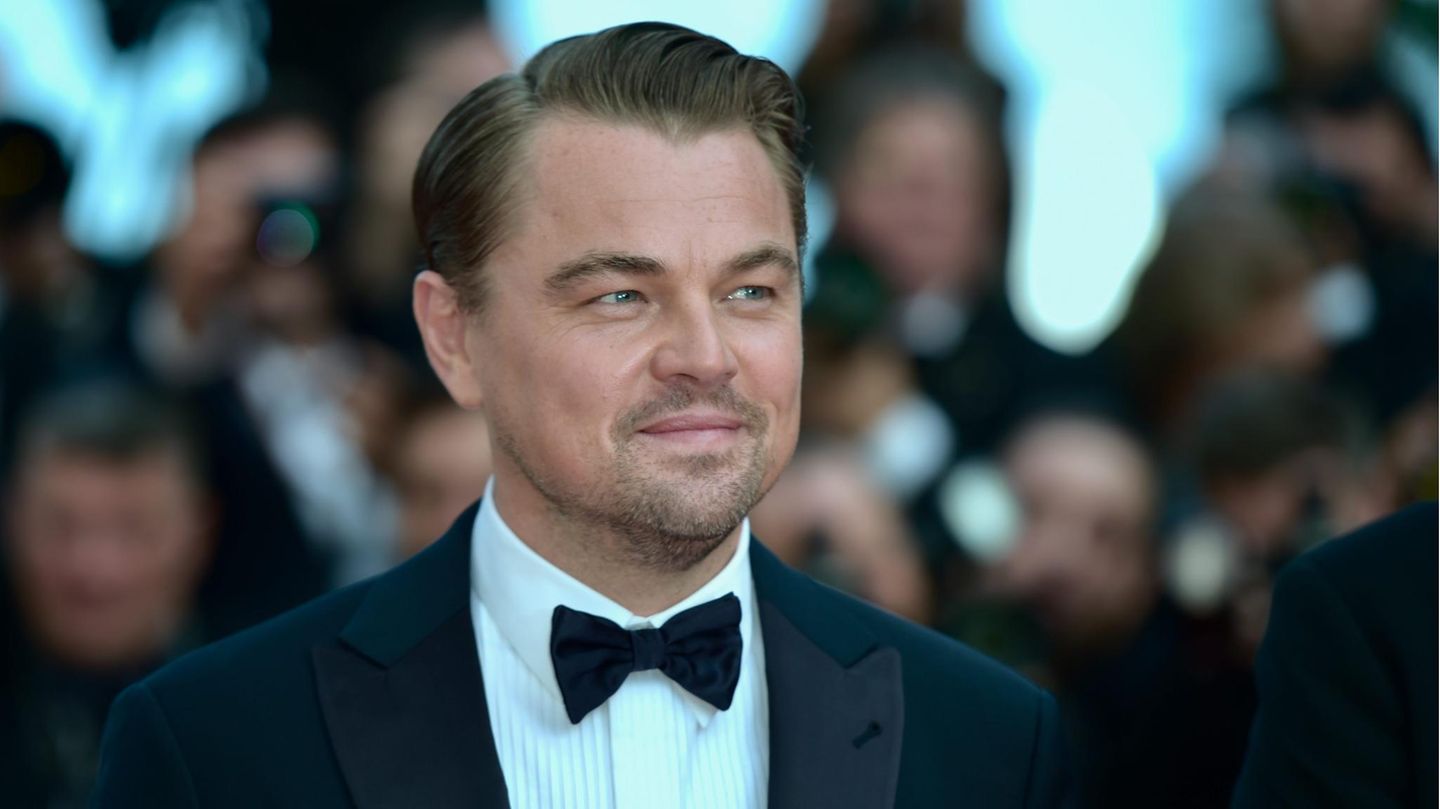 Leonardo DiCaprio auf de roten Teppich mit Fotografen im Hintergrund