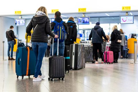 Reisende stehen vor der Gepäckaufgabe des Flughafens Hannover.