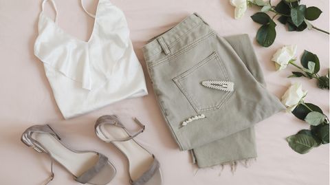 Lingerie-Top und Jeans liegen drapiert auf dem Boden