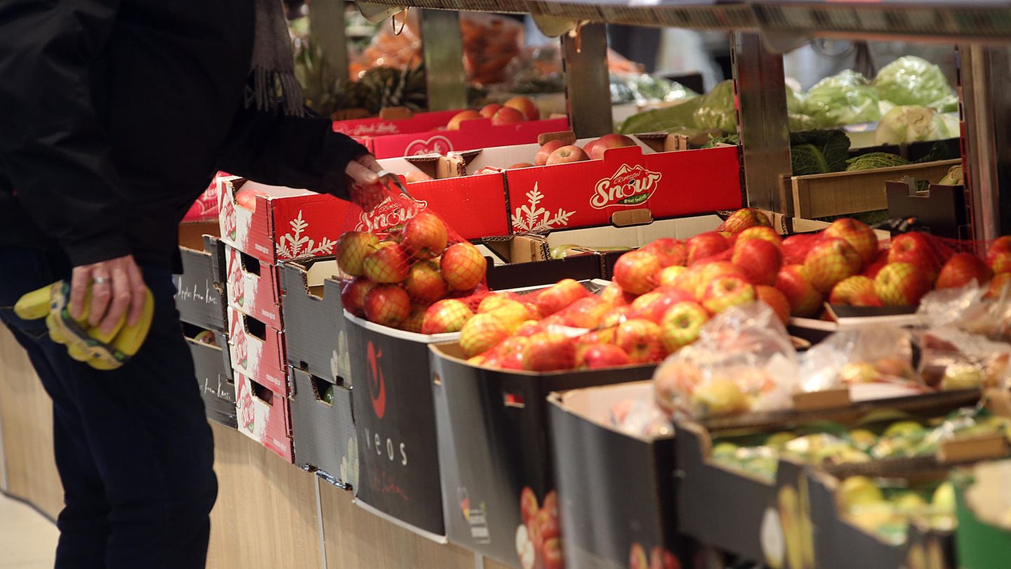 Ein Kunde im Supermarkt vor dem Obst- und Gemüseregal.
