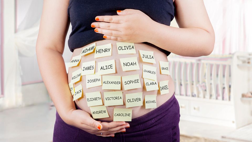 Eine Schwangere hat Post-Its auf ihren Bauch geklebt, auf denen viele verschiedene Namen stehen