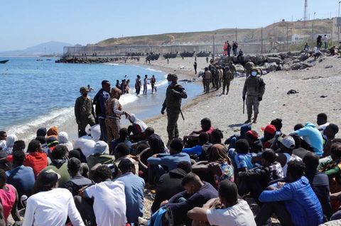 Die Migranten werden vom spanischen Militär bewacht.