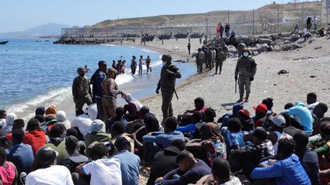 Die Migranten werden vom spanischen Militär bewacht.