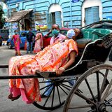 Indien, Kolkata: Eine an Covid-19 erkrankte Frau wird auf einer Rikscha zum Krankenhaus gebracht