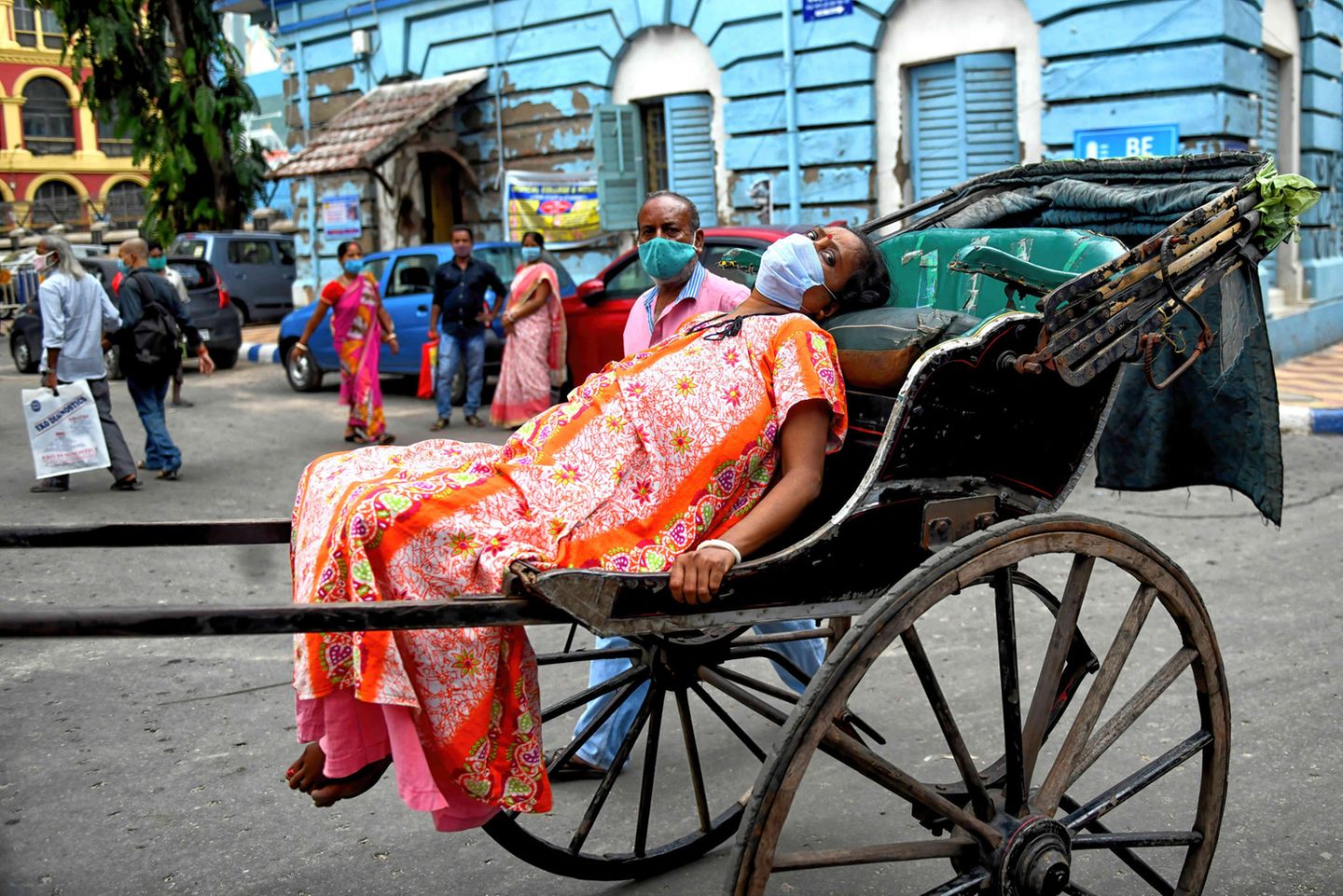 Indien, Kolkata: Eine an Covid-19 erkrankte Frau wird auf einer Rikscha zum Krankenhaus gebracht Indien, Kolkata: Eine an Covid-19 erkrankte Frau wird auf einer Rikscha zum Krankenhaus gebracht