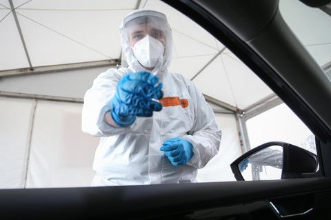 Test auf das Coronavirus: Ein Mitarbeiter einer Drive-In-Teststation nimmt einen Abstrich