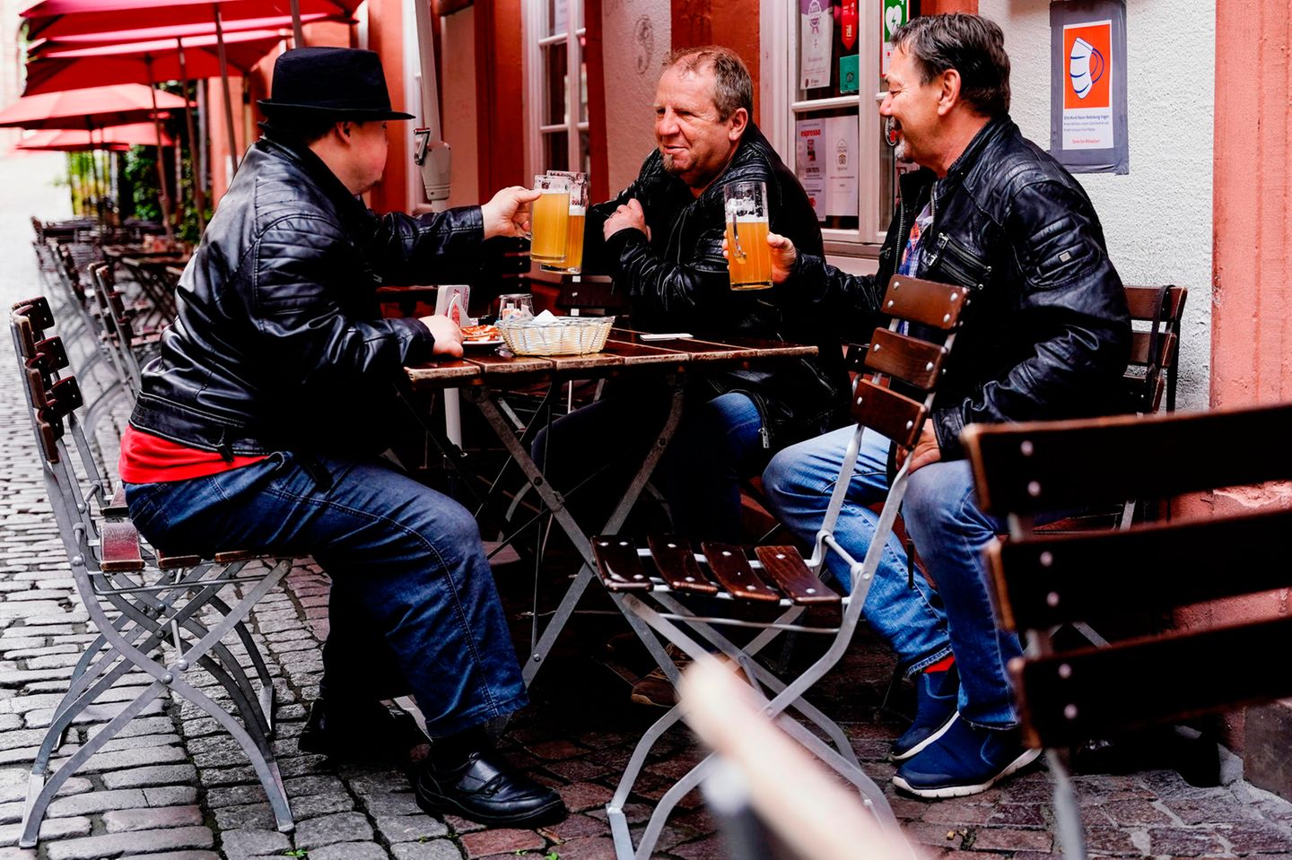 In Heidelberg sitzen Max, Uwe und Horst sitzen mit einem Bier vor einer Gaststätte in der Innenstadt