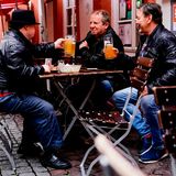 In Heidelberg sitzen Max, Uwe und Horst sitzen mit einem Bier vor einer Gaststätte in der Innenstadt