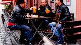 In Heidelberg sitzen Max, Uwe und Horst sitzen mit einem Bier vor einer Gaststätte in der Innenstadt