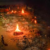 Vielerorts ist die Lage in dem 1,3-Milliarden-Einwohner-Land längst außer Kontrolle. Hier in Neu Delhi lodern Holzfeuer auf dem Gelände eines Krematoriums, in dem Opfer einer Covid-19 Erkrankung verbrannt werden.