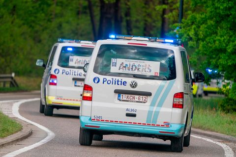 Zwei Polizeitransporter fahren durch ein Waldstück