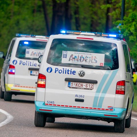 Zwei Polizeitransporter fahren durch ein Waldstück