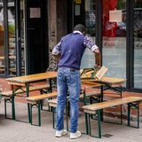 Ein Mitarbeiter eines Restaurants stellt im Hamburger Schanzenviertel Tische und Bänke auf