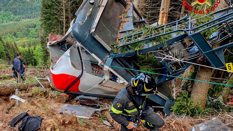 Rettungskräfte arbeiten am Wrack der abgestürzten Seilbahngondel