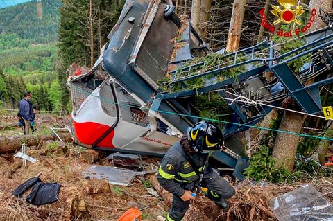 Rettungskräfte arbeiten am Wrack der abgestürzten Seilbahngondel