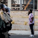 Eine Demonstrantin spricht mit Polizisten