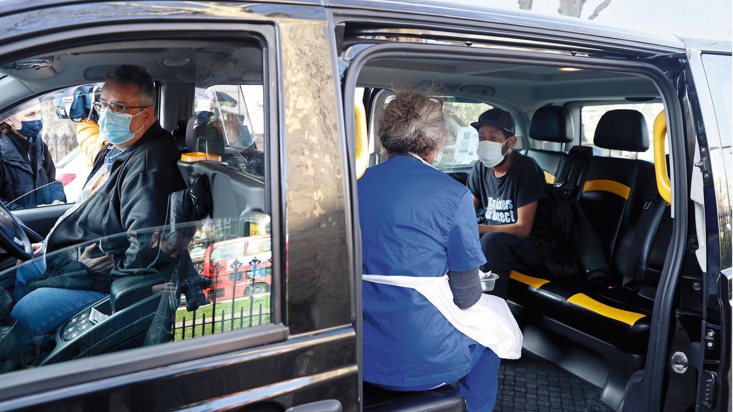 Dr Tamara Joffe prepares to administer an AstraZeneca vaccine against COVID-19 to Leslie Reid in the back of a London Taxi cab, during a pilot project of pop up vaccination drive called Vaxi Taxi in Kilburn, London, Sunday, Feb. 28, 2021. The pilot sche... In London bringt das "Vaxi Taxi" jene Menschen ins Impfzentrum, die sonst nie chauffiert werden – Arme, Kranke, Obdachlose