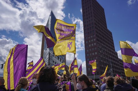 Bei einer Demonstration gegen steigende Mieten halten Teilnehmer Fahnen der Initiative "Deutsche Wohnen & Co. enteignen" in die Höhe