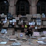 Ein Mann sitzt in einem Schildermeer nach einem Protestzug der "Black Lives Matter"-Bewegung