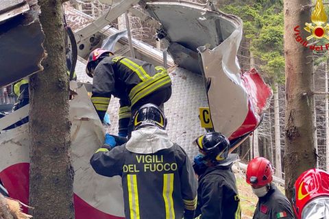 Feuerwehrmänner inspizieren die zerstörte Gondel