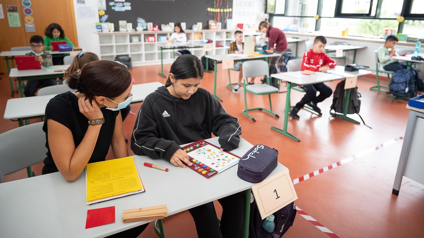 Lehrerin erklärt einer Schülerin die Aufgaben Lehrerin erklärt einer Schülerin die Aufgaben