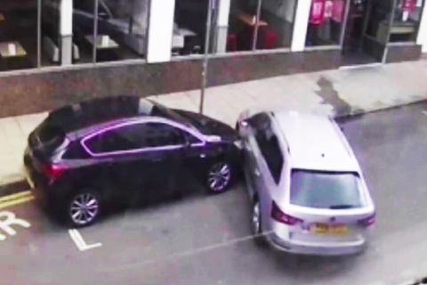 Silberner Kombi rammt geparktes Auto.