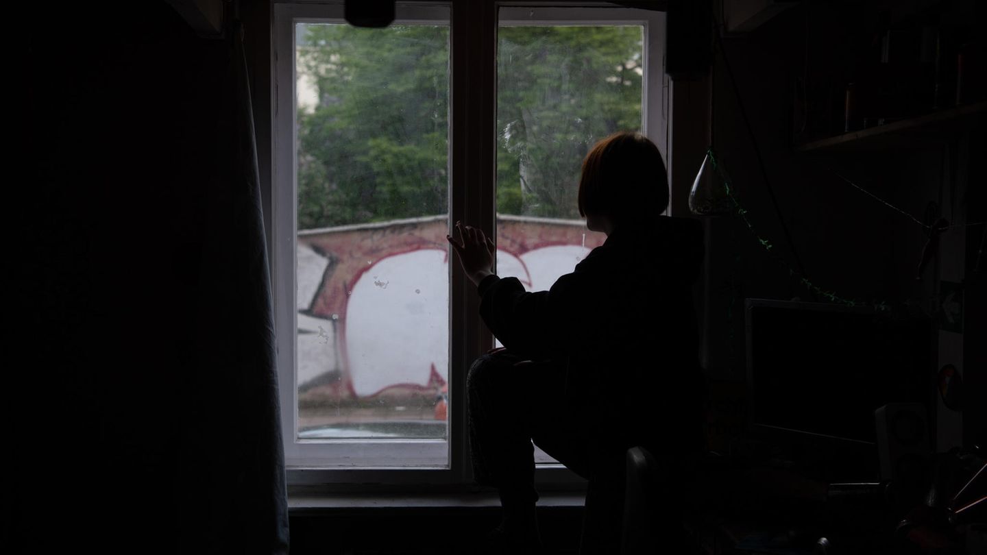 Ein Kind sitzt während des Corona Lockdowns am Fenster.