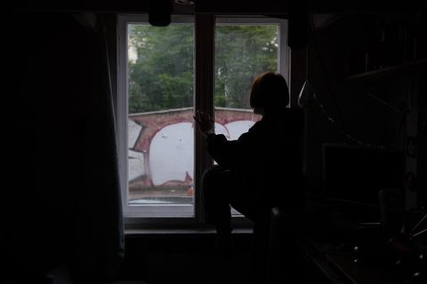 Ein Kind sitzt während des Corona Lockdowns am Fenster.