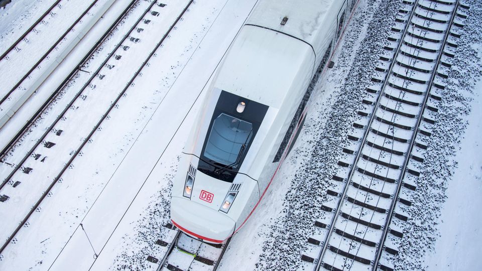  Ein ICE 4 fährt auf einem verschneiten Gleis