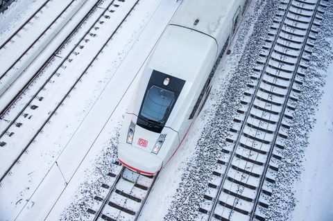  Ein ICE 4 fährt auf einem verschneiten Gleis