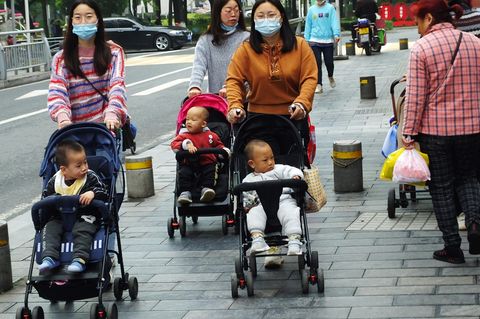 Drei Frauen schieben in Yichang in der Provinz Hubei Kinder im Buggy