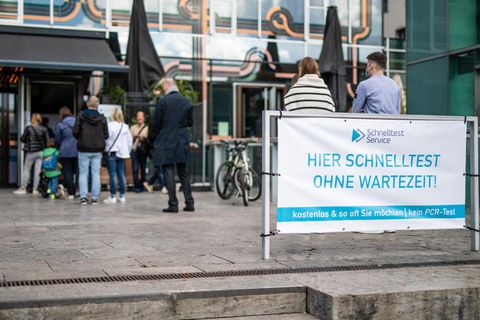 Baden-Württemberg, Stuttgart: Menschen stehen vor einem Testzentrum