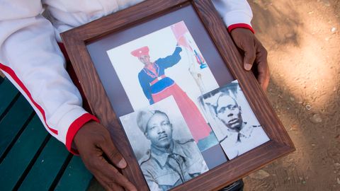 Ein Vertreter der Herero-Gemeinde zeigt in einem Park in Windhuk Fotos seiner Vorfahren, die vor dem Völkermord flohen