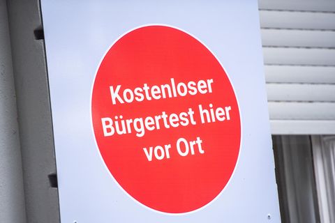 "Kostenloser Bürgertest hier vor Ort" steht an einem Covid-19-Testcenter
