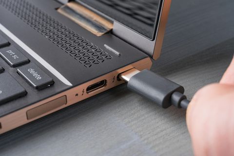 Ein Kabel von einem USB-C-Monitor wird in den USB-C-Port des Laptops gesteckt.