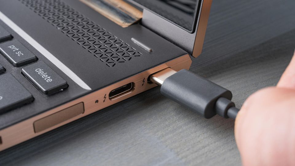 Ein Kabel von einem USB-C-Monitor wird in den USB-C-Port des Laptops gesteckt.