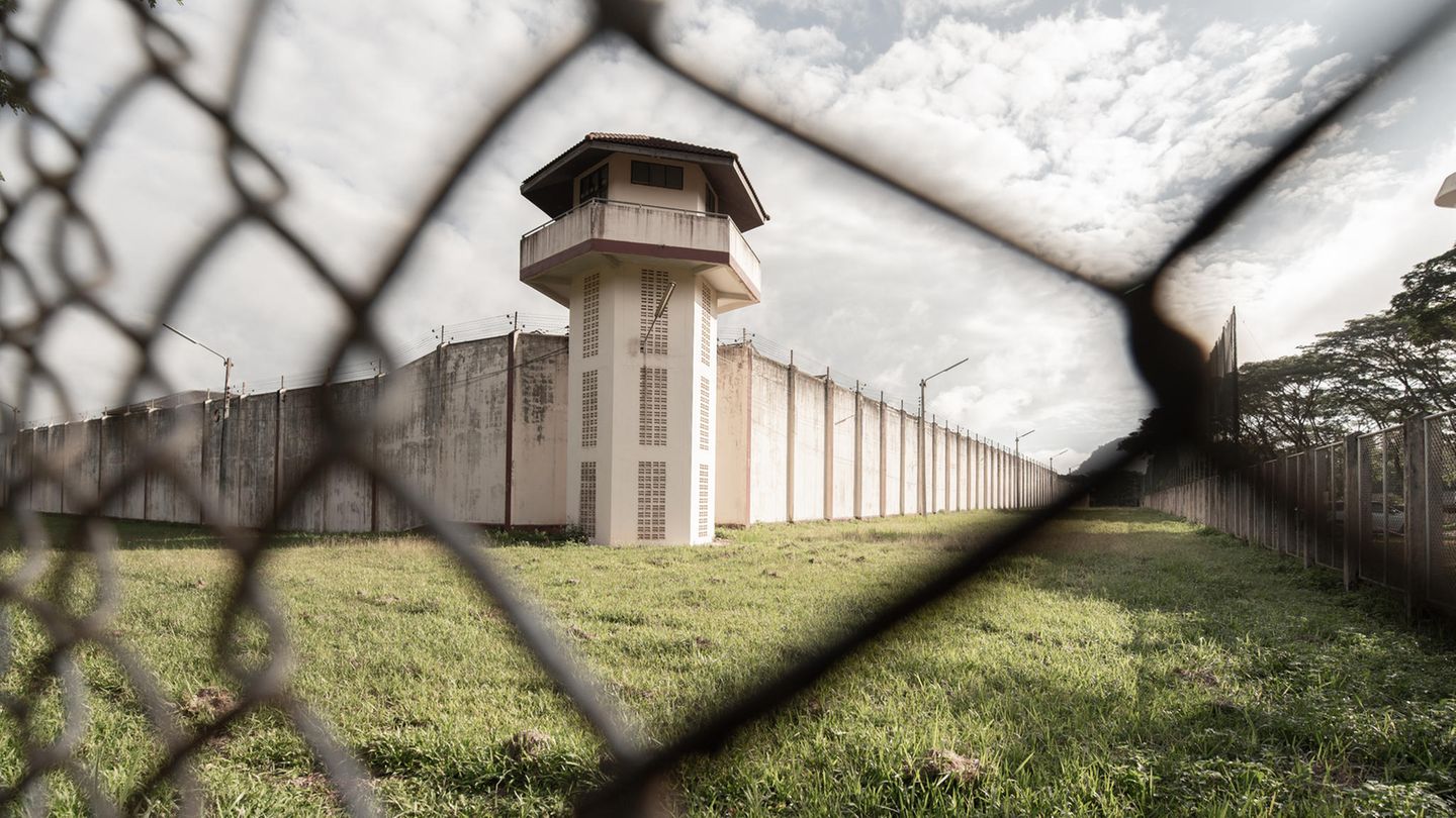 Gefängnis Blick durch Maschendrahtzaun auf Gefängnismauer und Wachturm