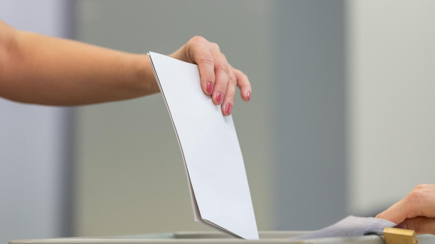 Eine Frau wirft ihren Stimmzettel in eine Wahlurne