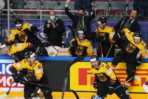 Deutsche Eishockeyspieler überspringen jubelnd die Bande
