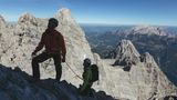 Mitten in der Watzmann Ostwand: Blick hinunter auf die Watzmannfrau (r.), das Watzmannkar und die Südwand des Hochecks (l.). Im Hintergrund erheben sich das Hohe Brett und der Hohe Göll.