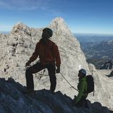 Mitten in der Watzmann Ostwand: Blick hinunter auf die Watzmannfrau (r.), das Watzmannkar und die Südwand des Hochecks (l.). Im Hintergrund erheben sich das Hohe Brett und der Hohe Göll.