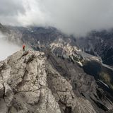 Die Mittelspitze ist mit 2713 Metern der höchste der drei Watzmanngipfel. Sie blitzt aus den Wolken hervor, während rechts unten sich durchs Wimbachtal mächtige Schuttströme aus Gestein ziehen.