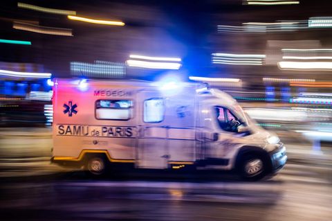 Ein weißer Transporter mit Blaulicht und "Samu Paris"-Schriftzug fährt durch eine nächtliche Stadt