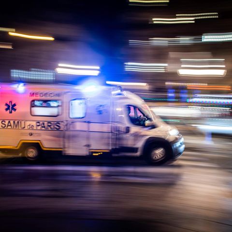 Ein weißer Transporter mit Blaulicht und "Samu Paris"-Schriftzug fährt durch eine nächtliche Stadt
