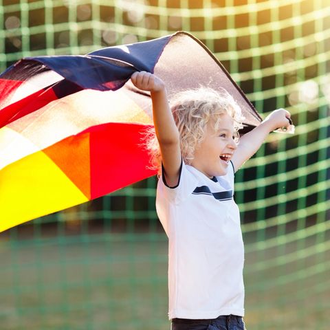 DFB-Trikot 2021: Kleiner Fußballfan mit Fan-Shirt und Deutschlandfahne