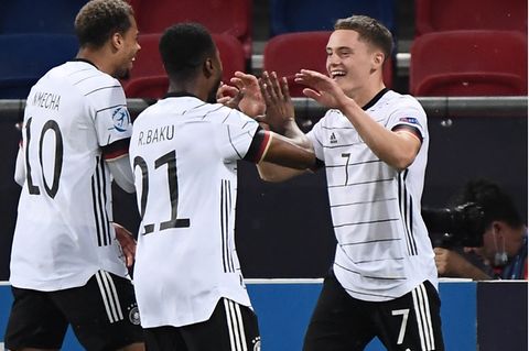 Lukas Nmecha und Ridle Baku gratulieren Florian Wirtz nach seinem zweiten Treffer gegen Holland