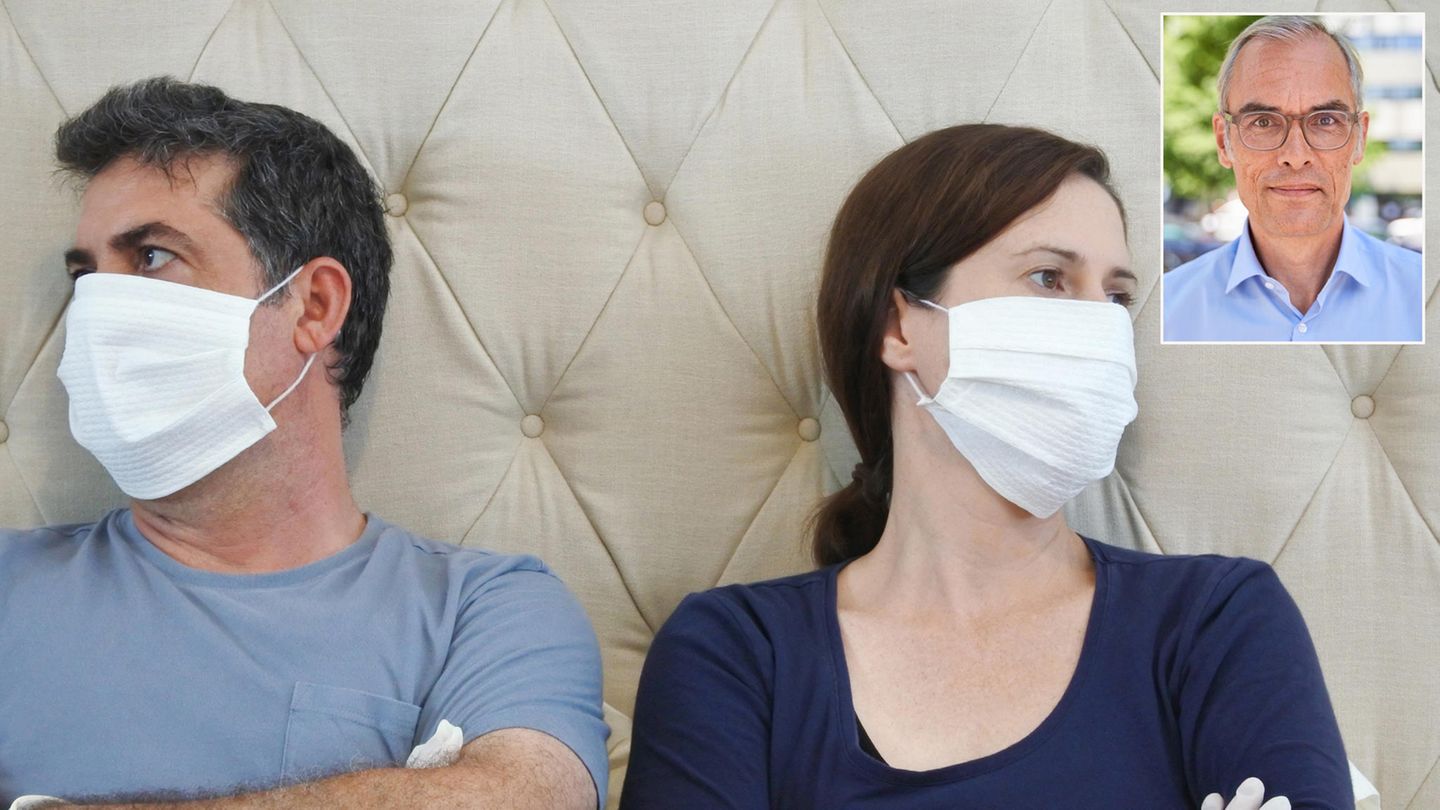 Paar Streit Corona Ein Mann und eine Frau lehnen sich mit verschränkten Armen an das Kopfteil eines Bettes und schauen voneinander weg